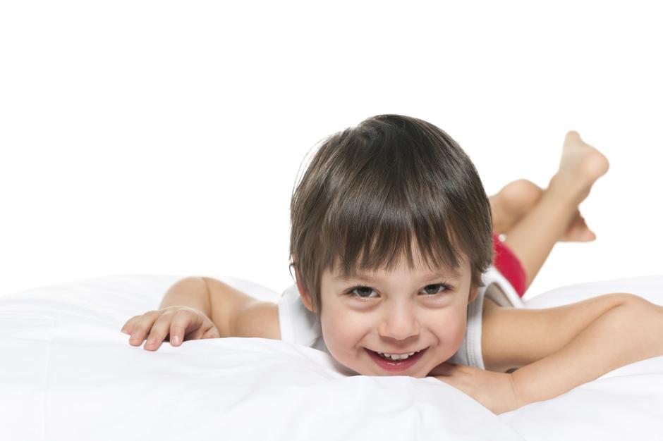 nasmijan dječak leži na krevetu | Author: Thinkstock